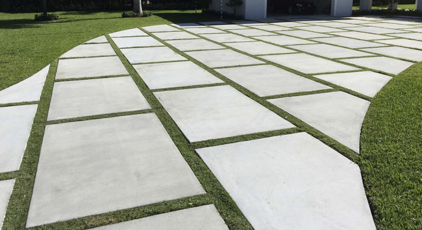 Modern concrete patio with geometric pavers and grass strips